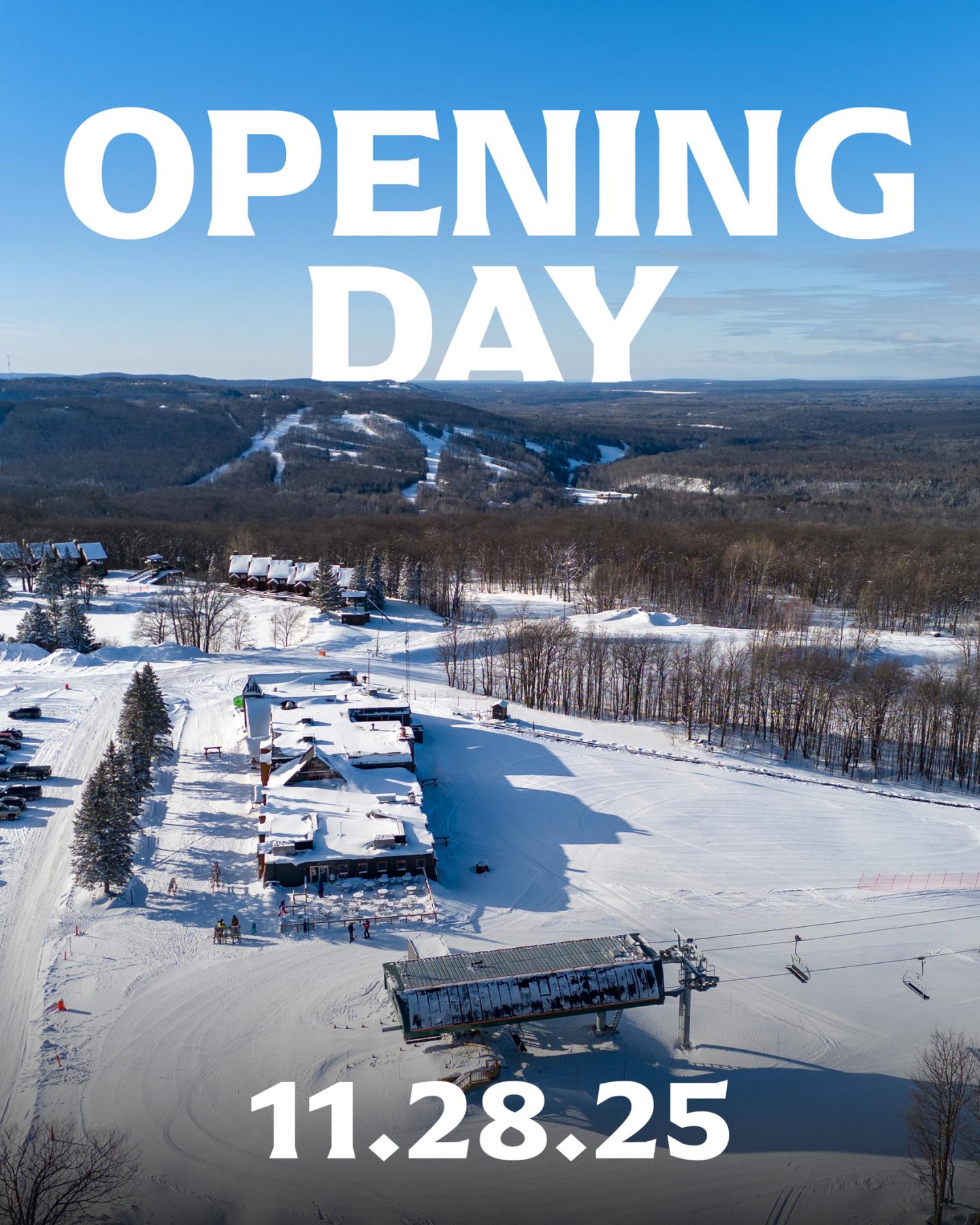 Snowy ski resort with mountains under a clear blue sky.
