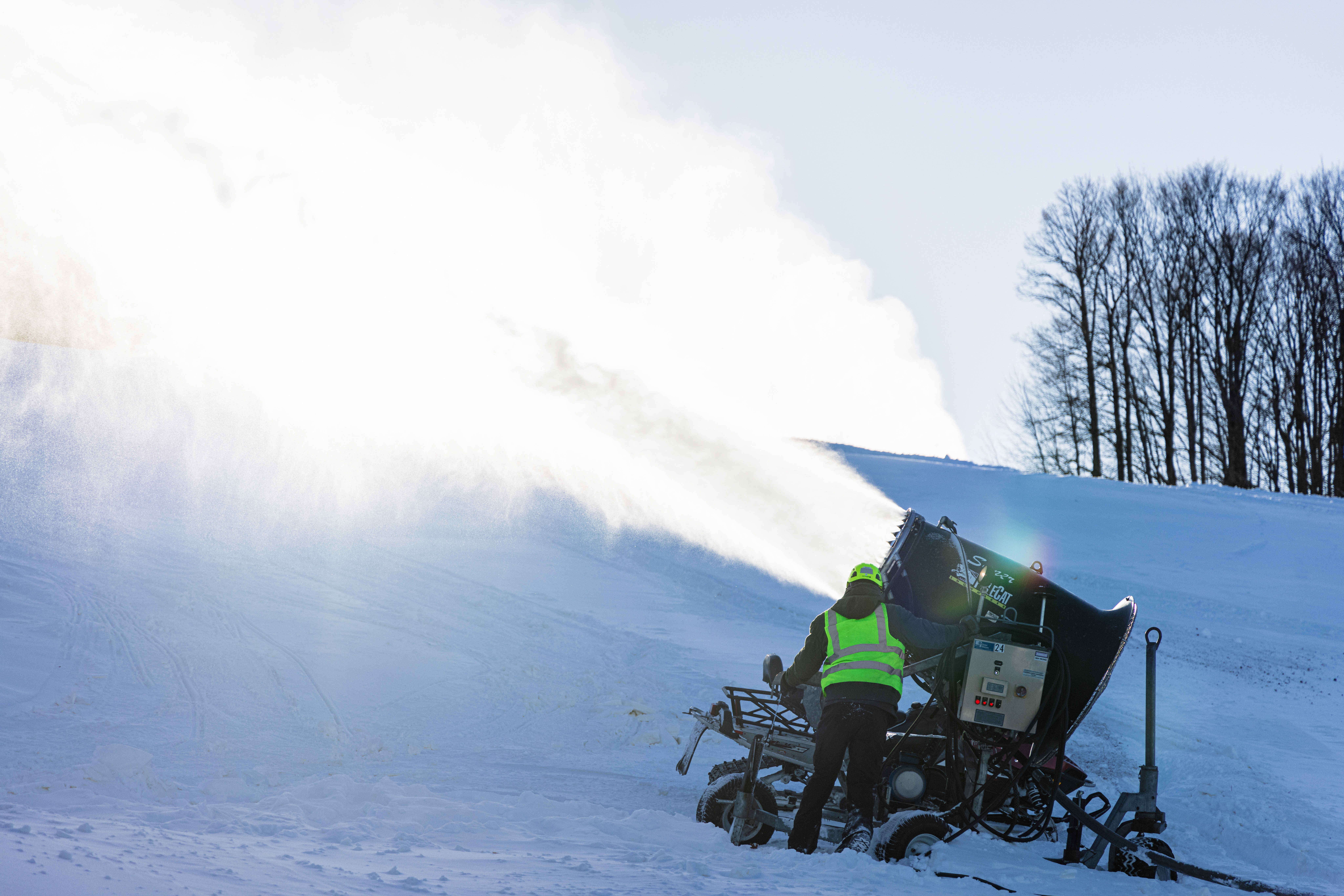 Snowmaker attending to a snowgun.