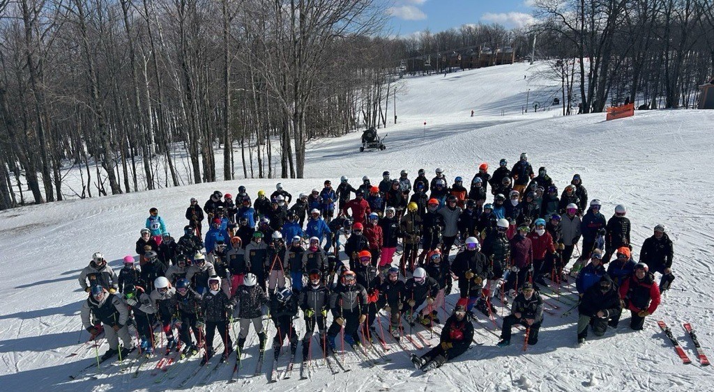 Group of ski racers posing for a photo opportunity.