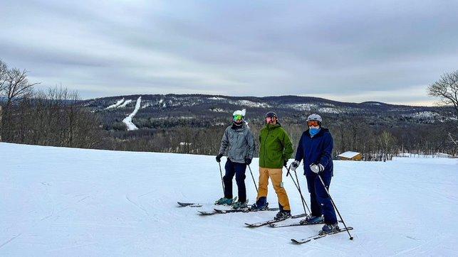 three skiers on a ridge