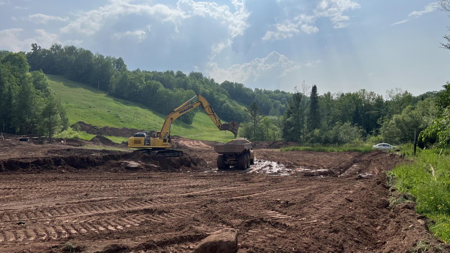 a digger grading the top of the soil