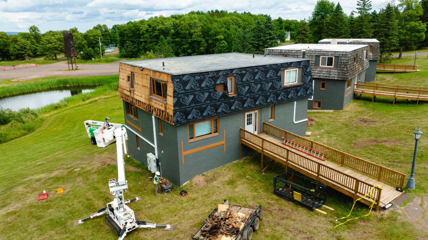 Workers remove old siding from the gabbro suites. 