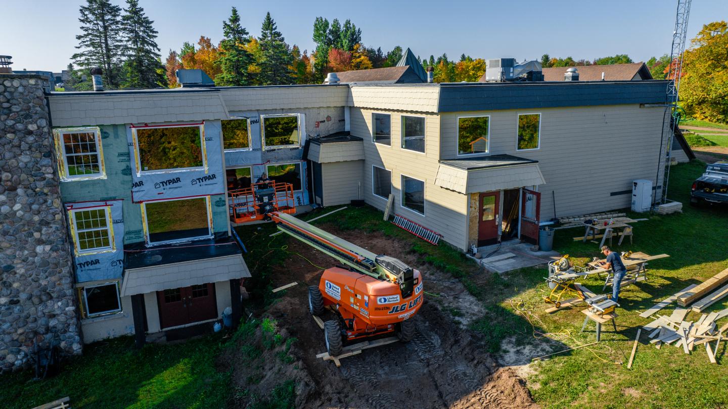 Construction workers install new siding on the Sugar Maple Chalet
