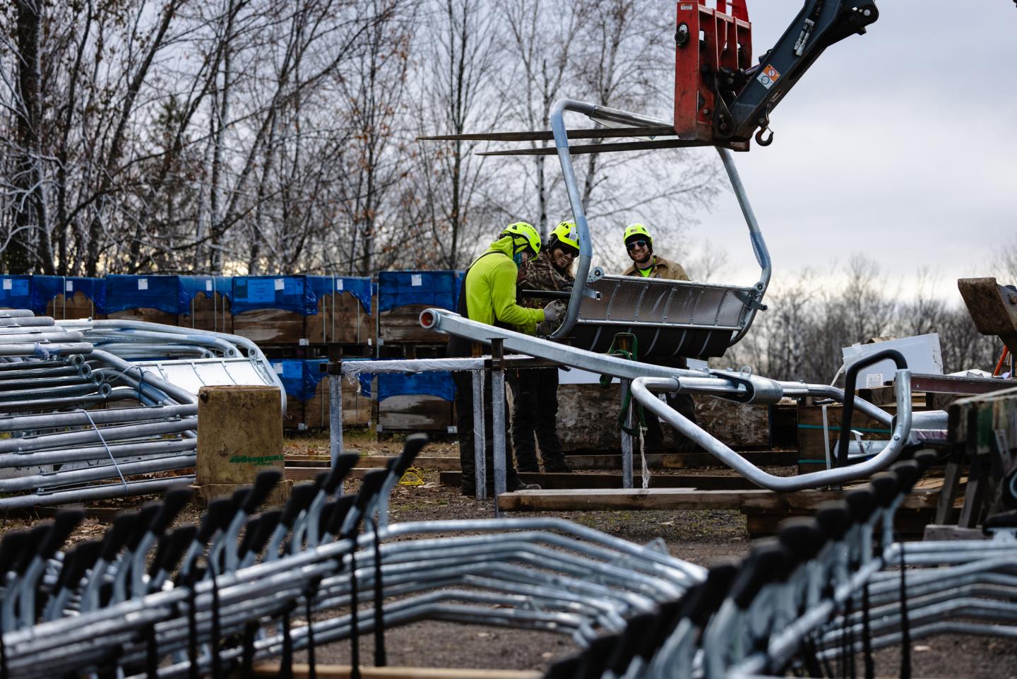 Workers attach a seat pad to a six person chair for the voyageur express.