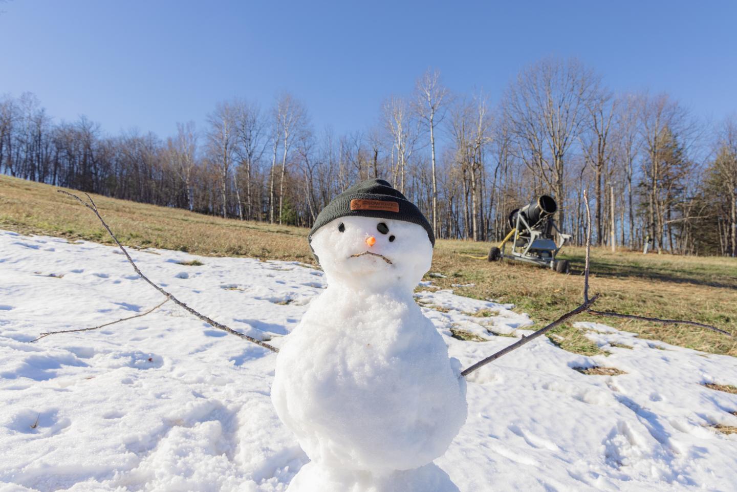 Snowman shedding a tear as it melts in the sun.