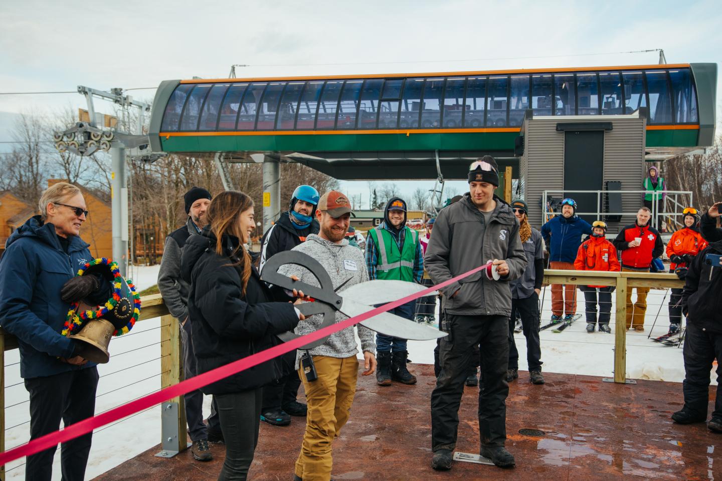 Charlotte Skinner using a giant scissors to cut the red ribbon