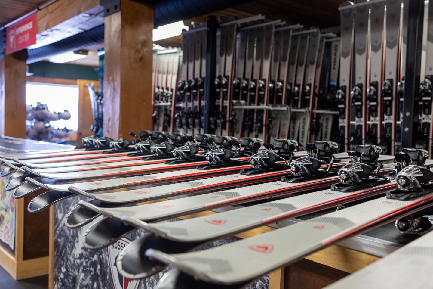 Ski rack with rows of skis lined up in a store.