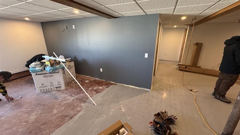 Basement under renovation with exposed ceiling and unfinished floor.