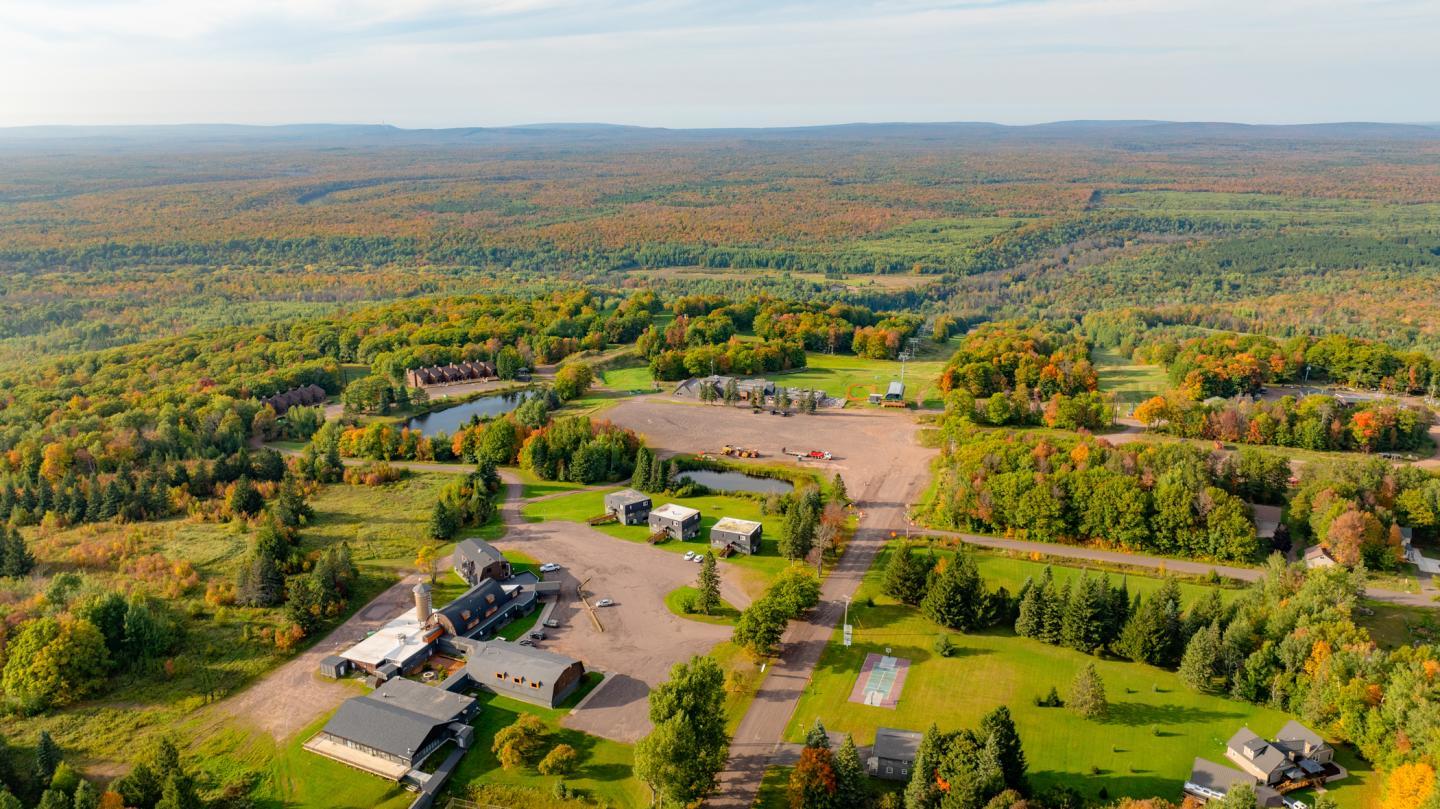 Aerial view of a rural landscape with scattered buildings and trees.