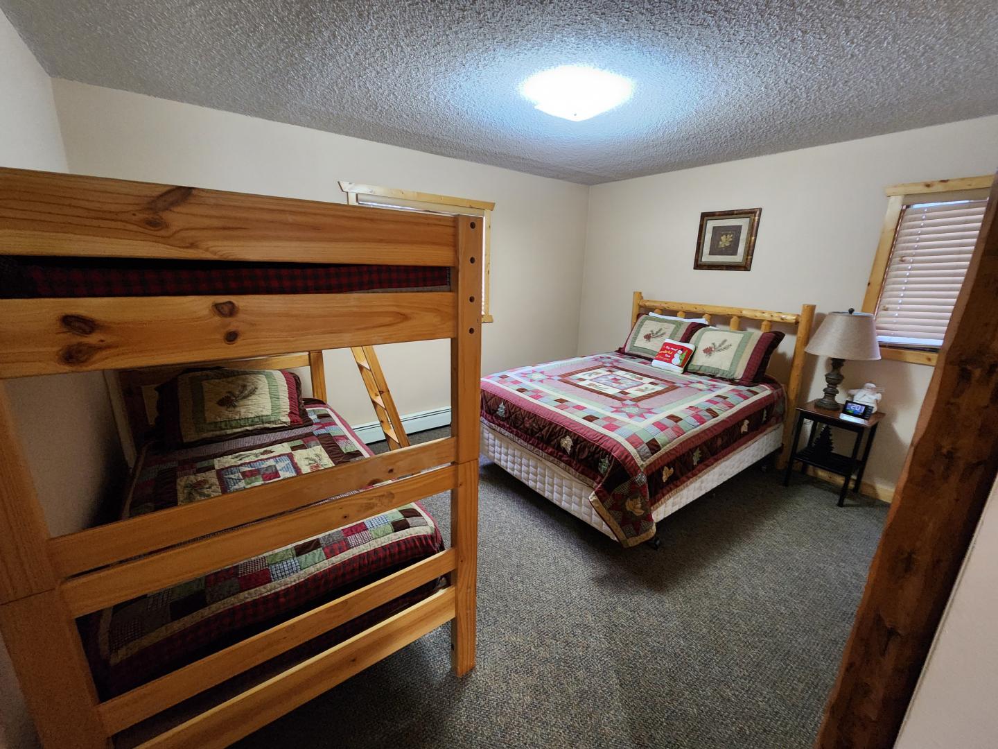 Cozy bedroom with a bunk bed, queen bed, and quilted bedding.
