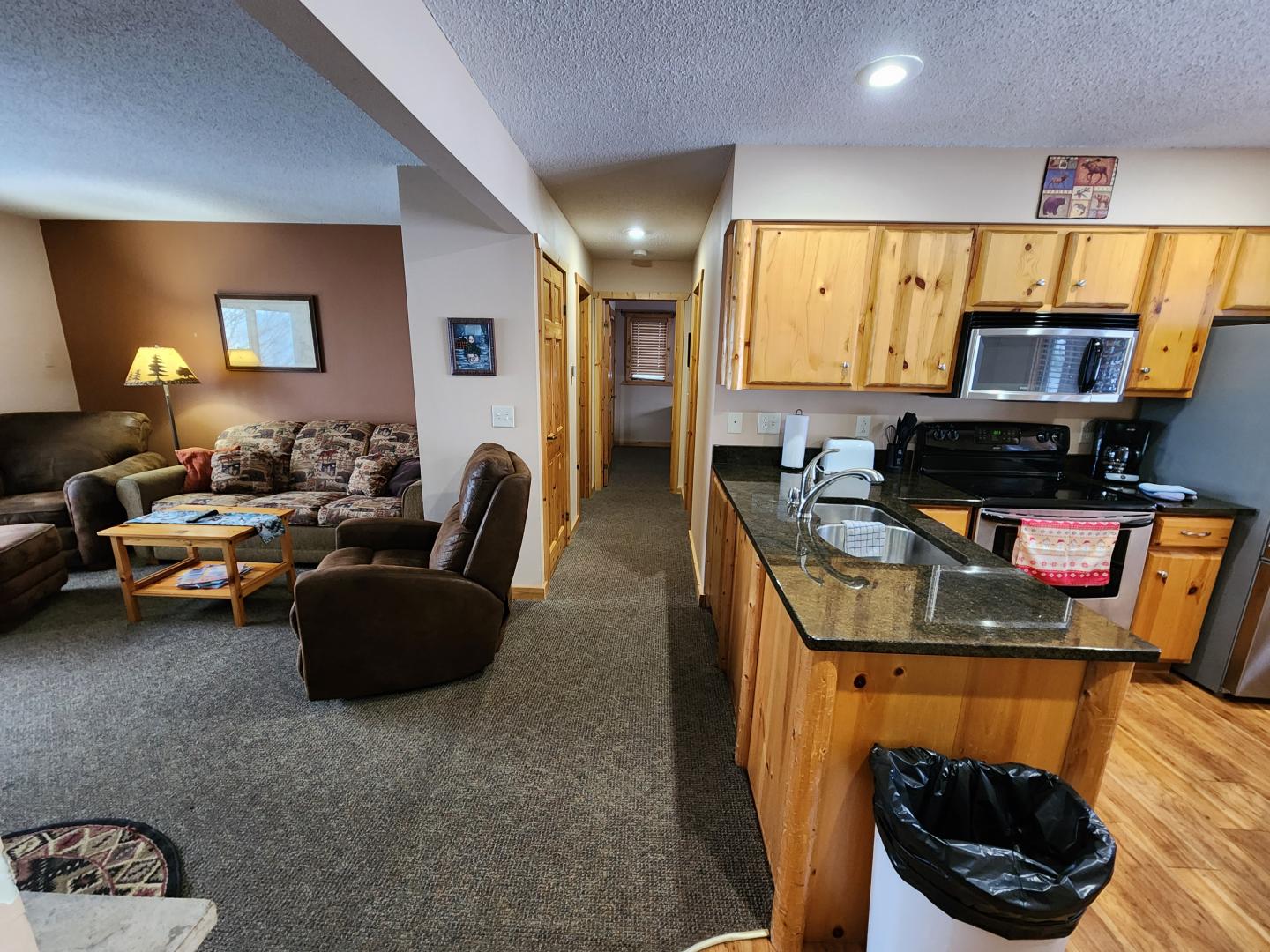 Cozy living room and kitchen with wooden cabinets and furniture.