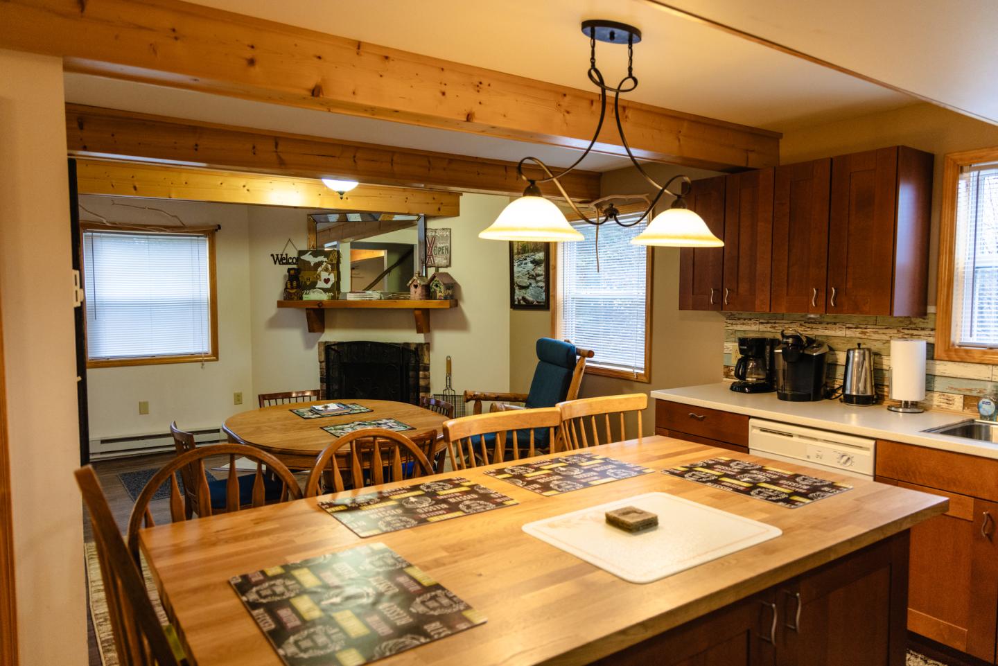 Cozy kitchen and dining area with wooden cabinets, island, and table.