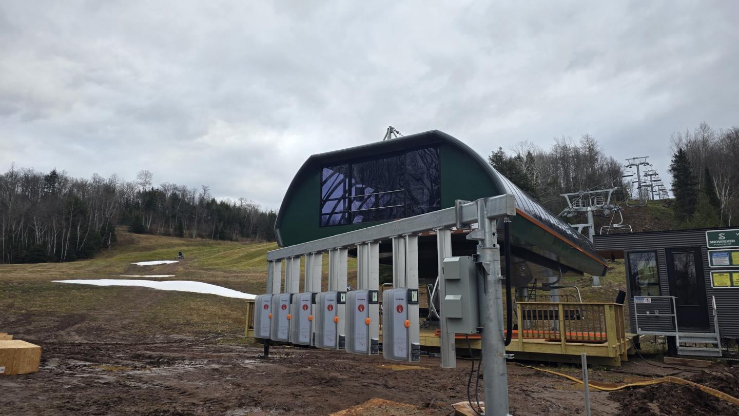 Ski resort building with a chairlift in a cloudy, snowy landscape.