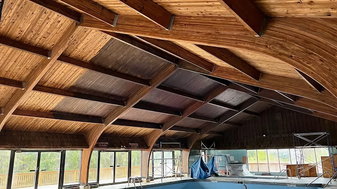 Wooden ceiling of an empty indoor pool area.