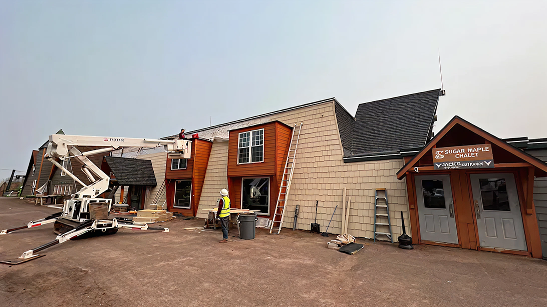 Building under maintenance with a crane and workers outside.
