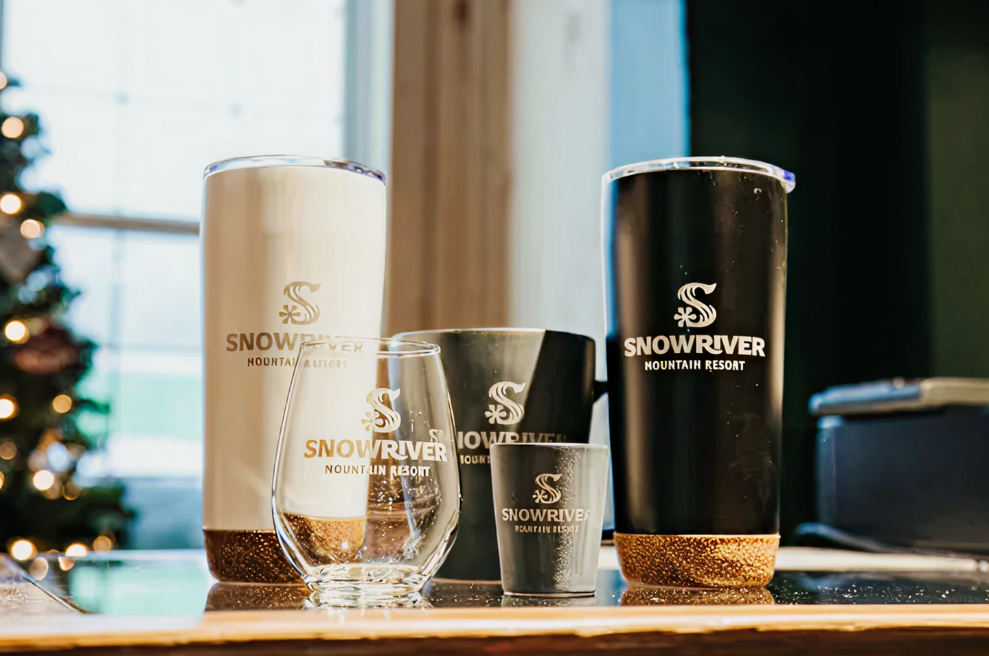 Assorted branded tumblers and glasses on a wooden table.